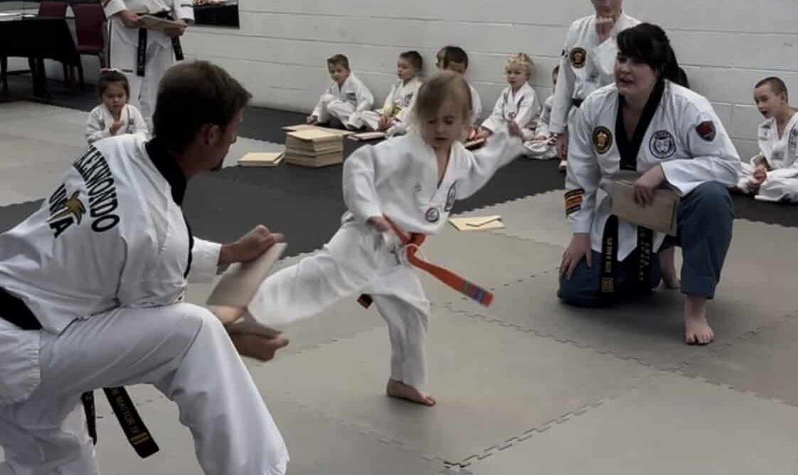 Orange Belt Child Kicking Through Board